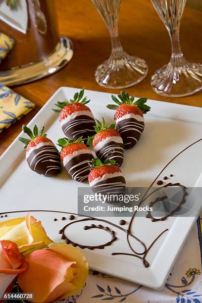 Chocolate covered strawberries on white plate.