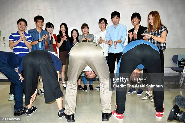 Ritsumeikan University professor Atsuki Higashiyama poses with students to show how objects look different when one bends over and views them through...