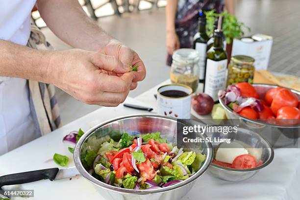 man seasoning tomato salad (salad cooking lesson) - olive oil bowl stock pictures, royalty-free photos & images