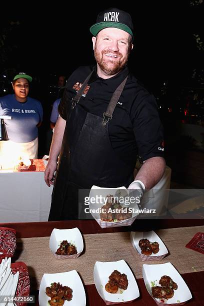 Chef Ash Fulk poses with his Chicken and Grits at Chicken Coupe hosted by Whoopi Goldberg and Andrew Carmellini at The William Vale on October 13,...