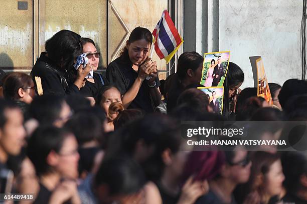 Onlookers weep as massive crowds line the streets during the procession of Thai King Bhumibol Adulyadej's body to his palace in Bangkok on October...