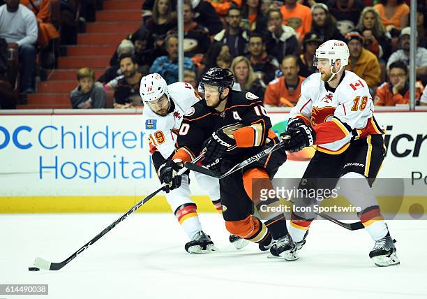Calgary Flames Right Wing David Jones [3924] and Calgary Flames Center Matt Stajan [3124] box out Anaheim Ducks Right Wing Corey Perry [2809] during...