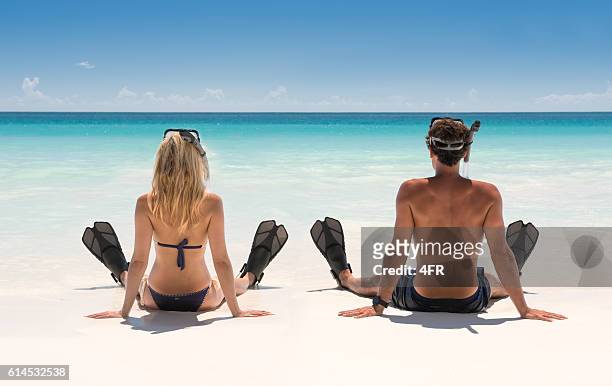 coppia con attrezzatura per lo snorkeling su una spiaggia idilliaca - snorkeling foto e immagini stock