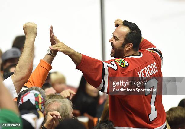 Blackhawks fan celebrates after catching a puck that went over the glass during game 7 of the NHL Western Conference Final between the Chicago...