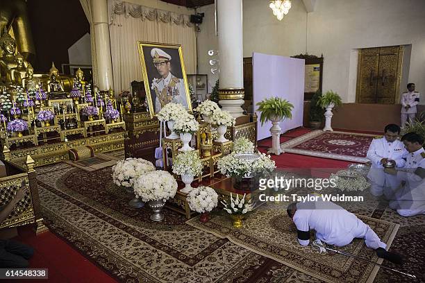 Uniformed official prostrates himself in front of a picture of the King during a ceremony at Wat Phra Singh on October 14, 2016 in Chiang Mai,...