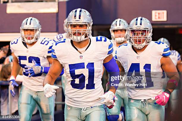 Kyle Wilber, Mark Nzeocha and Keith Smith of the Dallas Cowboys run onto the field before a game against the Cincinnati Bengals at AT&T Stadium on...