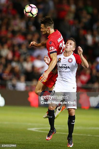 James Holland of Adelaide United competes for the ball with Nicolas Martinez of the Wanderers during the round two A-League match between Adelaide...