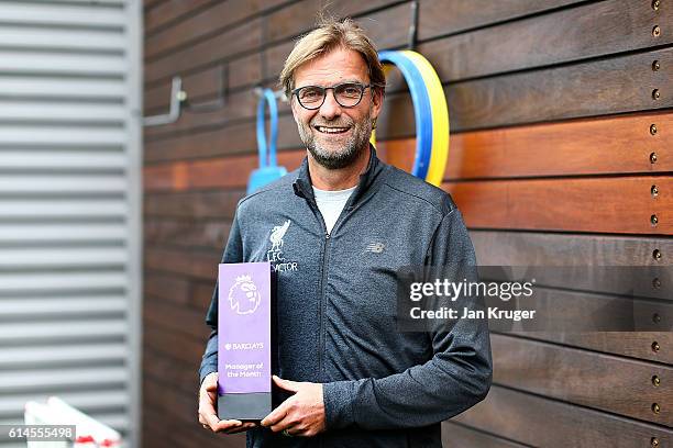 Jurgen Klopp poses with the manager of the month trophy at Melwood Training Ground on October 13, 2016 in Liverpool, England.