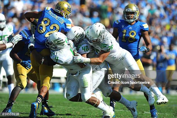 Eldridge Massington is taken down by Oregon Erick Dargan, Rodney Hardrick, and Joe Walker during an NCAA football game between the Oregon Ducks and...