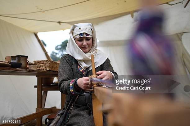 Historical re-enactor works on a tablet loom ahead of a re-enactment of the Battle of Hastings, on October 14, 2016 in Battle, England. Re-enactors...