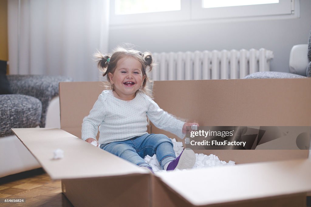 Baby-Mädchen spielen in Box mit Styropor Pellets