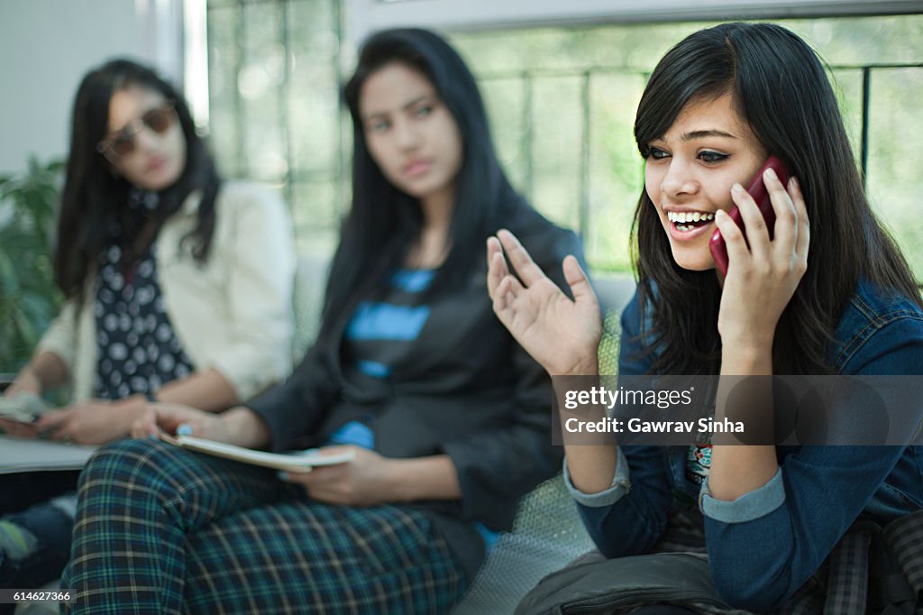 Young businesswoman talking loud on phone in office waiting room.