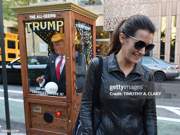 People looks at the 'All-Seeing Trump', a fortune-telling fairground attraction bearing the likeness of Republican presidential candidate Donald...