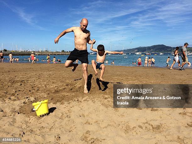 father and son playing on the beach. getaria, gipuzkoa province, basque country - guipuzco provincie stockfoto's en -beelden