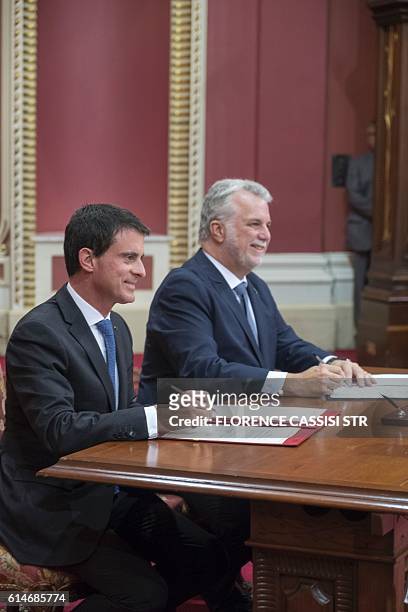 French Prime Minister Manuel Valls poses at the National Assembly of Quebec with Quebec Premier Philippe Couillard as they sign a free trade...