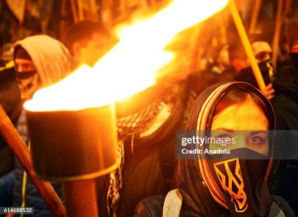 Ukrainian nationalists of regiment "Azov" and "Right sector" party and their supporters, with torches in hands attend "March of the nation" in Kiev,...