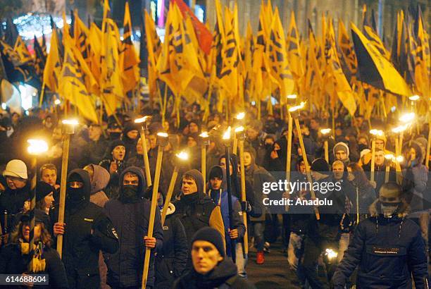 Ukrainian nationalists of regiment "Azov" and "Right sector" party and their supporters, with torches in hands attend "March of the nation" in Kiev,...