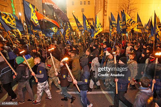 Ukrainian nationalists of regiment "Azov" and "Right sector" party and their supporters, with torches in hands attend "March of the nation" in Kiev,...