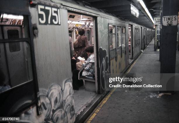 Riders in a graffiti covered Subway car stopped at the Times Square Station in 1976 in New York City, New York.