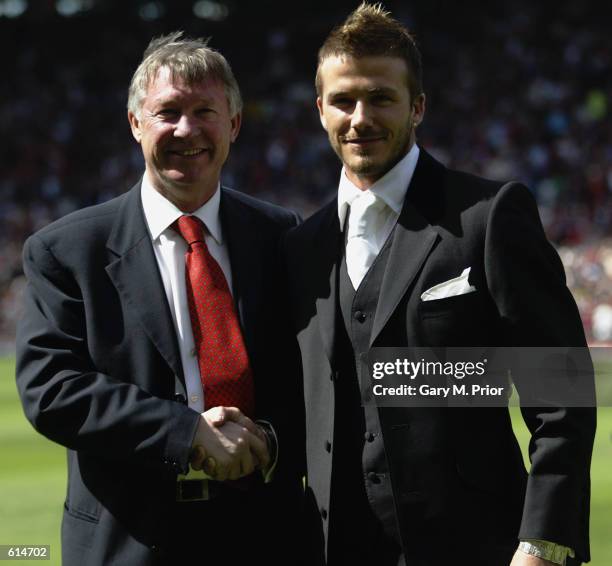 David Beckham of Manchester United and manager Alex Ferguson stand next to each other on the pitch after Beckham signed a new lucrative contract to...