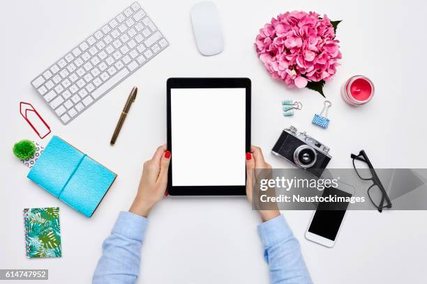 blogger holding digital tablet by desk supplies on white background - computer mouse table stock pictures, royalty-free photos & images