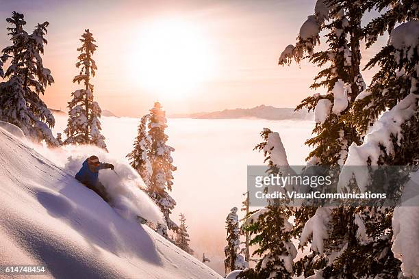 skier carving fresh powder in sunset. - skiing mountain stock pictures, royalty-free photos & images