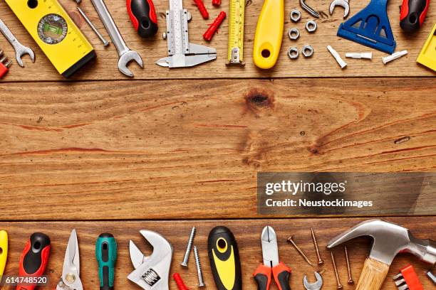 various hand tools are arranged on wooded table - multi tool stock pictures, royalty-free photos & images