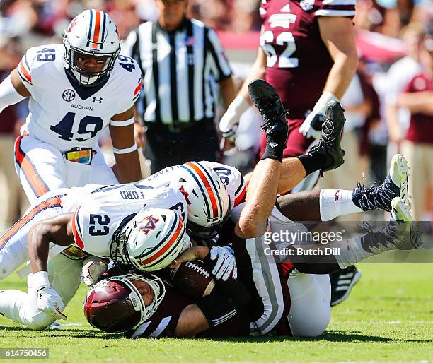 Quarterback Nick Fitzgerald of the Mississippi State Bulldogs is sacked by defensive back Johnathan Ford of the Auburn Tigers and linebacker Tre'...