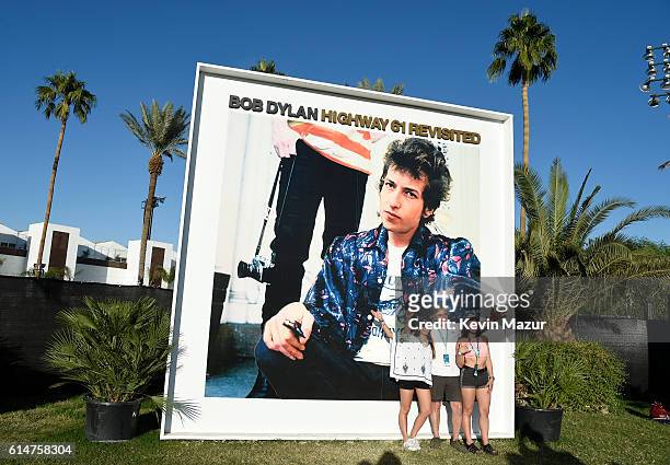 Music fans pose in front of the Bob Dylan "Highway 61 Revisited" album cover displayed on the grounds at Desert Trip at The Empire Polo Club on...
