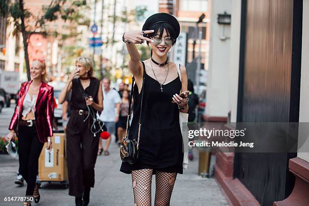 Korean model Sora Choi throws a peace sign after the Creatures of the Wind show and wears an all black outfit including sailor-style hat,...