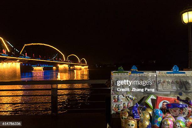Night market selling North Korea souvenir goods beside the Yalu river. Dandong is the largest Chinese frontier city, bordering with Sinuiju of North...