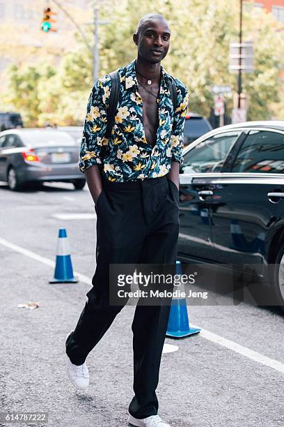 West African model Aly Ndiaye wears an open green and yellow floral shirt with relaxed-fit black trousers after the Lacoste show at Spring Studios on...