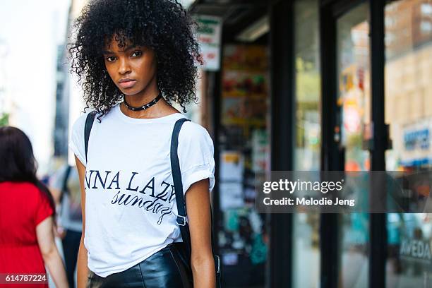 Model Djenice Duarte wears a leather choker necklace with metal crosses and a white t-shirt with text on September 10, 2016 in New York City.