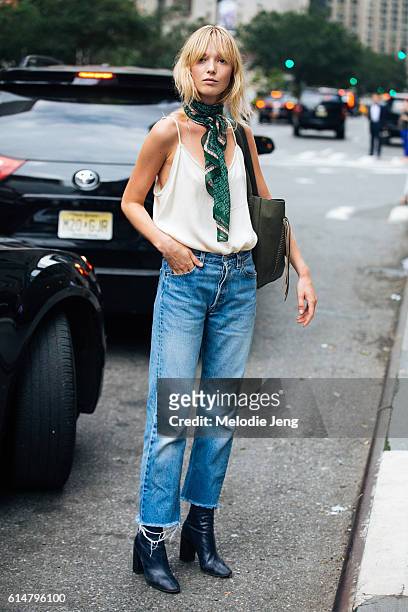 Danish model Ulrikke Hoyer wears a green scarf around her neck, a white silk tank top tucked into cutoff jeans, and booties after the Akris show on...