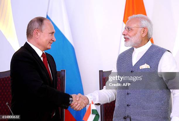 India Prime Minister Narendra Modi shakes hands with Russian President Vladimir Putin during the exchange of agreements and joint press statements...