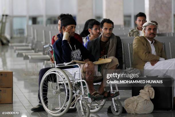 Wounded Yemeni men sit in the airport in Sanaa on October 15 as they wait for an Omani plane to evacuate them. An Omani aircraft landed in the...