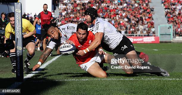 Sean Maitland of Saracens dives over for the first try despite being tackled by Ma'a Nonu and Leigh Halfpenny during the European Rugby Champions Cup...