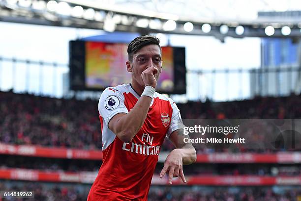 Mesut Ozil of Arsenal celebrates scoring his sides third goal during the Premier League match between Arsenal and Swansea City at Emirates Stadium on...