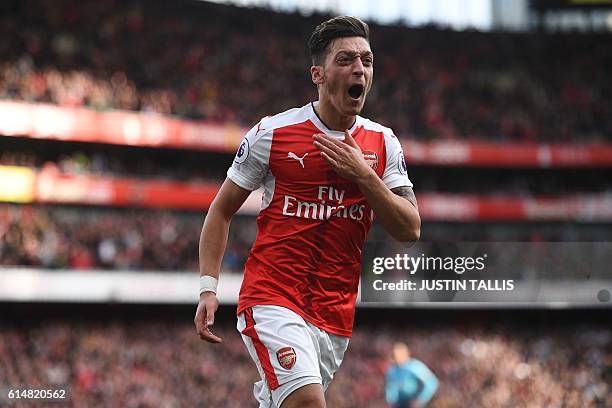 Arsenal's German midfielder Mesut Ozil celebrates after scoring their third goal during the English Premier League football match between Arsenal and...