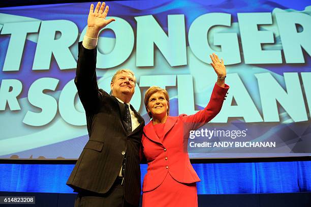 Scottish National Party deputy leader Angus Robertson and leader Nicola Sturgeon and First Minister of Scotland wave after delivering her keynote...