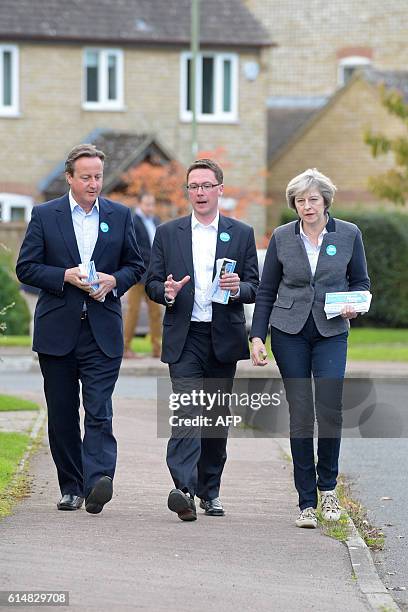 British Prime Minister Theresa May posts fliers through doors with former Prime Minister David Cameron and Robert Courts, the Conservative candidate...