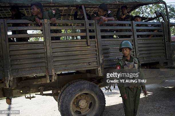 Myanmar soldiers arrive with residents displaced from the conflict between a group of armed Muslim militants and government troops, to take refuge at...