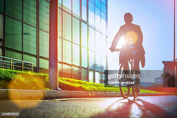 hübscher mann mit dem fahrrad neben dem modernen bürogebäude - fahrrad grün stock-fotos und bilder
