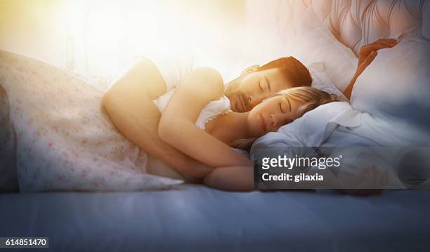 sleeping couple. - man and woman cuddling in bed stockfoto's en -beelden