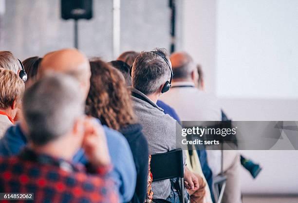 business seminar konferenz mit kopfhörerübersetzung - übersetzung stock-fotos und bilder