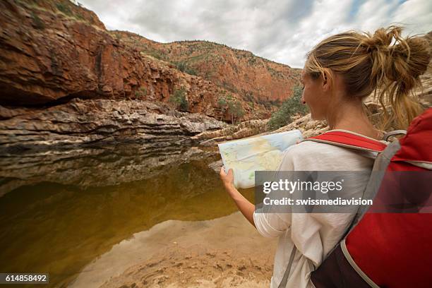 caucasian female hiking in the outback reads map for directions - bush live stockfoto's en -beelden