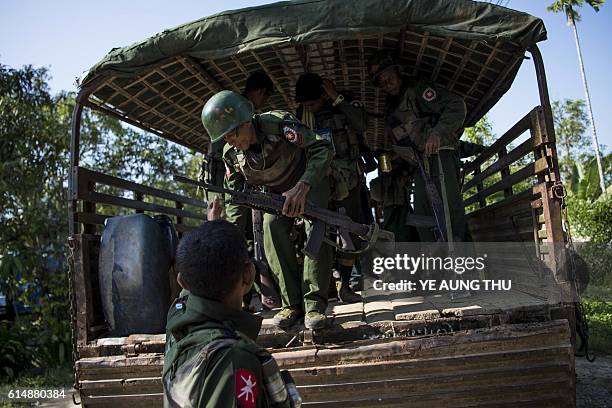 Myanmar soldiers arrive as they bring the residents displaced from the conflict between a group of armed Muslim militants and government troops, to...