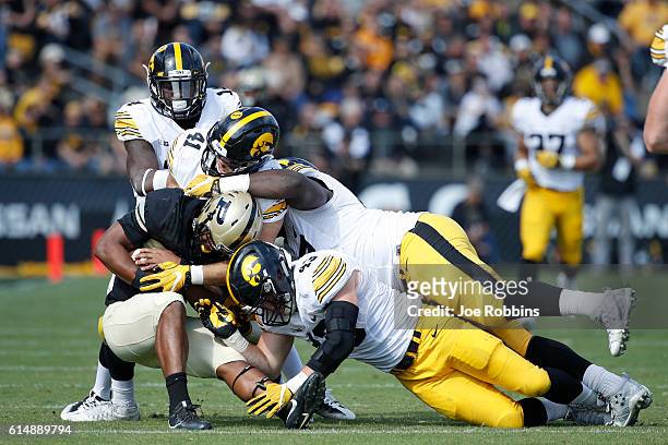 Several Iowa Hawkeyes defenders make a tackle for loss against Brian Lankford-Johnson of the Purdue Boilermakers in the second half of the game at...