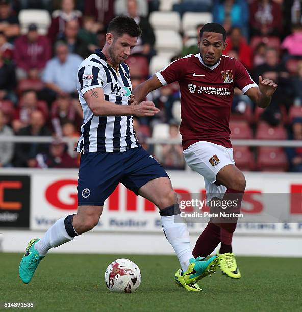 Calum Butcher of Millwall looks to play the ball watched by Kenji Gorre of Northampton Town during the Sky Bet League One match between Northampton...