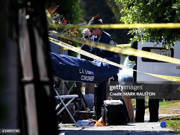 Body is removed by the Los Angeles County coroner staff after three people were killed during a shooting after a dispute at a pop-up Jamaican...